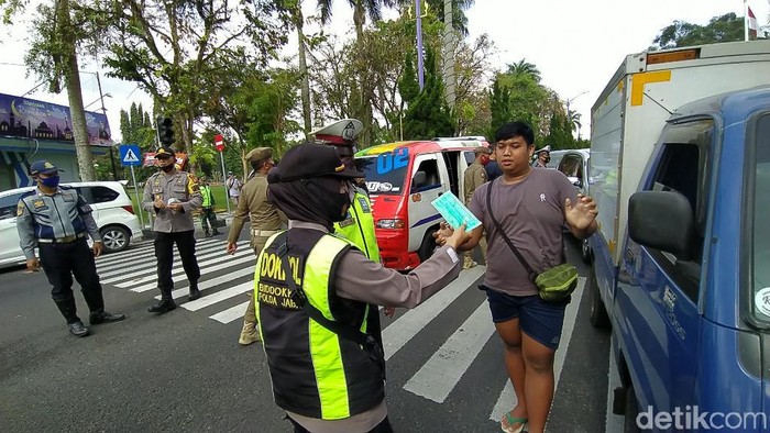 Petugas tegur warga yang tak menggunakan masker.