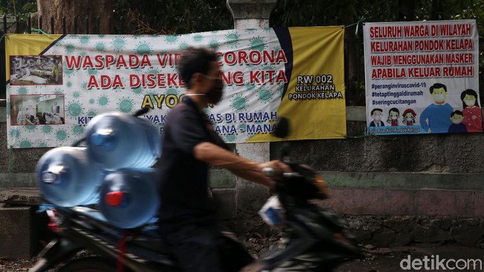 Sosialisasi Bahaya COVID-19 Lewat Spanduk Warga melintasi spanduk bahaya COVID-19 di Komplek DKI, Pondok Kelapa, Jakarta Timur, Selasa (15/9/2020). Berbagai cara terus dilakukan untuk mensosialisasikan bahaya COVID-19 hingga lingkungan perumahan RT dan RW.