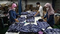 Para karyawan pergudangan bekerja dengan memakai masker. 