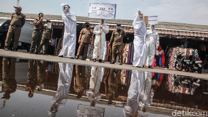 Hiii....'Pocong' Blusukan ke Pasar Kampanye Bahaya COVID-19 Petugas Kecamatan Larangan melakukan sosialisasi bahaya COVID-19 di Pasar Cipadu, Kota Tangerang. Mereka menggunakan topeng dan karakter pocong.
