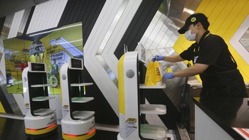 Peran staf manusia juga masih dibutuhkan, yaitu untuk menambahkan toping ke bahan yang dimasak sebelum akhirnya dibungkus dan diberikan ke robot untuk disajikan. AP Photo/Ahn Young-joon  