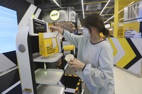 In this Sunday, Sept. 13, 2020, photo, a robot carries a takeout bag with food at No Brand Burger in Seoul, South Korea. From order to pick-up, customers don’t need a single face-to-face interaction. All they need to do is to click the menu they want on a kiosk touchscreen, pay and wait for a serving robot to bring their takeout bag to the pick-up spot. (AP Photo/Ahn Young-joon)