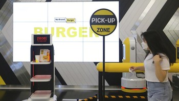 Sambil menunggu makanan, pelanggan bisa mengambil foto atau melihat kinerja robot berbentuk kapsul yang mengingatkan pada karakter minion dari film animasi Despicable Me. AP Photo/Ahn Young-joon  
