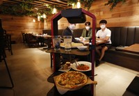 Lee Youngjin, team leader of AI Platform Business Team at KT Corp., speaks about AI serving robot ahead of a demonstration at a restaurant in Seoul, South Korea, Tuesday, Sept. 15, 2020.  (AP Photo/Lee Jin-man)