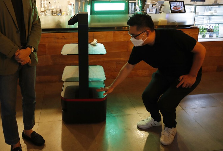 Lee Youngjin, team leader of AI Platform Business Team at KT Corp., speaks about AI serving robot ahead of a demonstration at a restaurant in Seoul, South Korea, Tuesday, Sept. 15, 2020.  (AP Photo/Lee Jin-man)