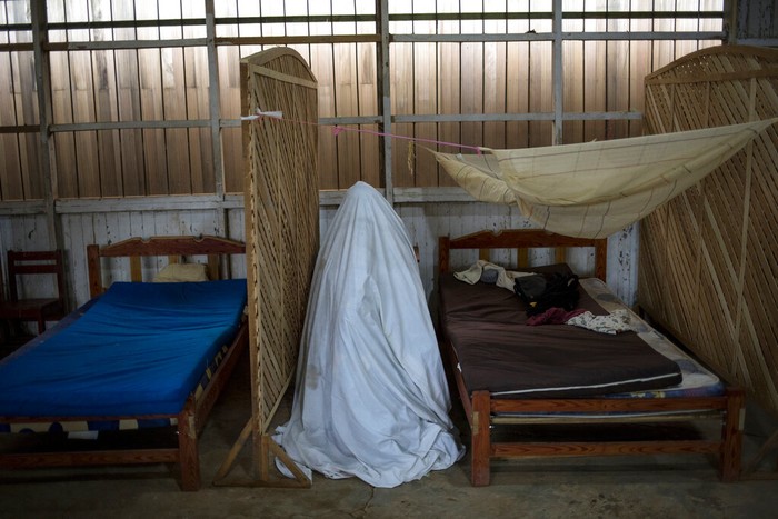 Children watch a government team remove the body of Susana Cifuentes, who died from symptoms related to the new coronavirus at the age of 71, in the Shipibo Indigenous community of Pucallpa, in Peru’s Ucayali region, Monday, Aug. 31, 2020. The Shipibo had tried to prevent COVID-19’s entrance by blocking off roads and isolating themselves. But in May many came down with fevers, coughs, difficulty breathing and headaches. (AP Photo/Rodrigo Abd)