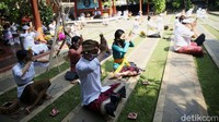 Umat Hindu bersembahyang dengan mengenakan pakaian adat yang didominasi warna putih. 