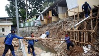 Para petugas Sudin SDA Kota Jakarta Selatan tersebut tampak mengevakuasi material longsor di saluran penghubung Jagakarsa pascalongsor.