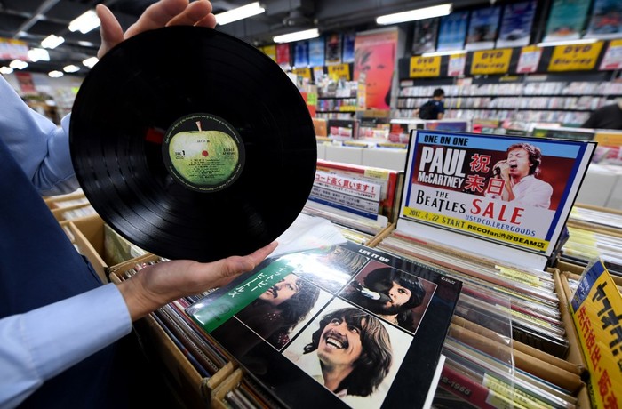 A shop manager shows off a period Japanese pressing of The Beatles final studio album Let It Be at the RECOfan music shop in Tokyos Shibuya district on June 29, 2017. - Sony said on June 29 it will start making vinyl records again on the back of surging demand for a technology that the Japanese firm abandoned three decades ago. (Photo by Toshifumi KITAMURA / AFP)