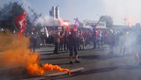 Sejumlah pegawai Bridgestone tampak membawa flare atau suar saat menggelar aksi unjuk rasa di depan pabrik ban yang berada di kawasan Bethune, Prancis, tersebut.