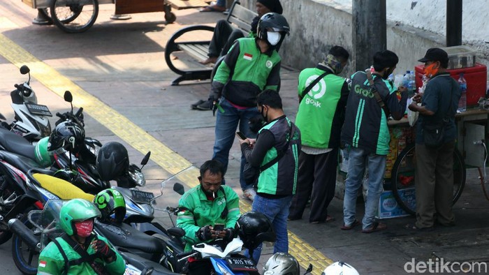 Ojek online dan taksi diijinkan beroperasi selama PSBB DKI Jakarta. Namun di kawasan Senayan, mereka terlihat berkerumun saat menunggu penumpang.