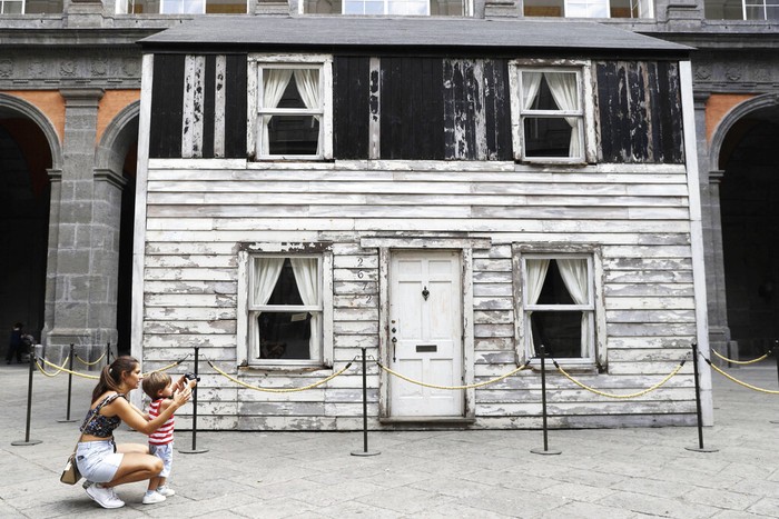 Visitors look through a window of the house of U.S. civil rights campaigner Rosa Parks, rebuilt by artist Ryan Mendoza, for public display, in Naples, Italy, Tuesday, Sept. 15, 2020. It’s the latest stop for the house in a years-long saga that began when Parks’ niece saved the tiny two-story home from demolition in Detroit after the 2008 financial crisis. (AP Photo/Gregorio Borgia)