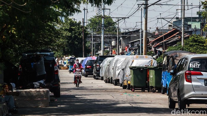 Kendaraan warga terparkir di jalan inspeksi Kali Krendeng yang berseberangan dengan Jalan Subur Baru, Jakarta Barat, Kamis (17/9/2020). Kendaraan tersebut memenuhi jalan inspeksi yang bersisian dengan rel kereta api. Jalanan lebar dan kosong dimanfaatkan warga untuk memarkir inap kendaraan roda empat.