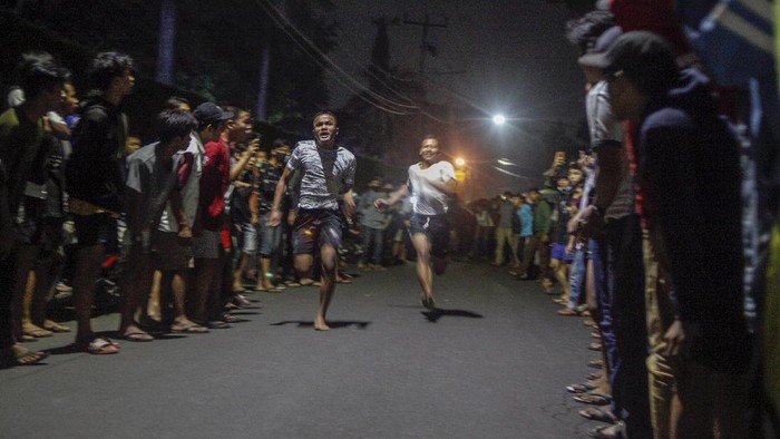 Dua orang pebalap lari liar adu lari berjarak 100 meter di Jalan Raya Ciri Mekar, Cibinong, Kabupaten Bogor , Jawa Barat, Sabtu dini hari (12/9/2020). Menurut mereka balap lari liar ini lebih positif ketimbang balap motor dan balap mobil liar yang selama ini ada di kota-kota besar di Indonesia, walaupun kegiatan itu mengganggu lalu lintas di kawasan tersebut. ANTARA FOTO/Yulius Satria Wijaya/hp.