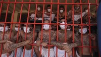 Di balik jeruji besi terlihat para narapidana kelas kakap itu memakai masker dan hanya bertelanjang dada.  