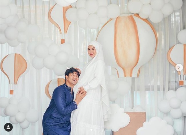 Irish Bella dan Ammar Zoni kembali berpose mesra untuk pemotretan kehamilan. Dengan perut Irish yang semaki besar, Ammar pun berpose seolah mencium bayi di kandungan sang istri.  Foto: Instagram @_irishbella_