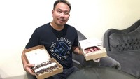 Hobi ngemil di sela aktivitasnya membuat Vicky sering pose bareng makanan. Kali ini ia memegang dua kardus isi kue manis bertabur topping cokelat dan keju. Foto: instagram @vickyprasetyo777