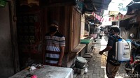 Seorang warga menyusuri pasar yang tutup sementara itu untuk menyemprotkan disinfektan.