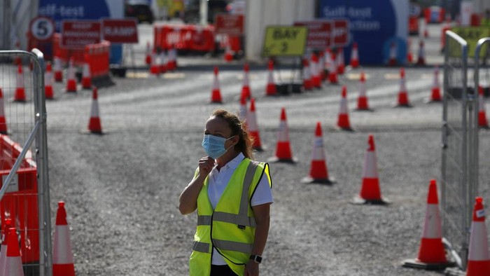 Staff waits in front of empty lanes of a Covid-19 drive thru testing facility at Twickenham stadium in London, Thursday, Sept. 17, 2020. Britain has imposed tougher restrictions on people and businesses in parts of northeastern England on Thursday as the nation attempts to stem the spread of COVID-19, although some testing facilities remain under-utilised. (AP Photo/Frank Augstein)