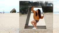 Seorang wanita berpose dengan karya instalasi di Swell Sculpture Festival ke-18 di Pantai Currumbin di Currumbin, Australia.