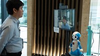 Sebuah robot mengukur suhu tubuh seorang pria selama pengujian di sebuah gedung komersial di Tokyo, Jepang. Foto: Dok. Tokyo metropolitan government/Handout via Xinhua