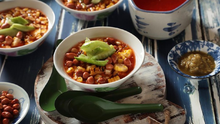 Asinan Jagung Bakar, a snack salad dish of char-grilled corn kernel in sweet, spicy, salty and tangy vinegar dressing. Topped with roasted peanuts and cucumber pickles. The dish is popular in Bogor, West Java.