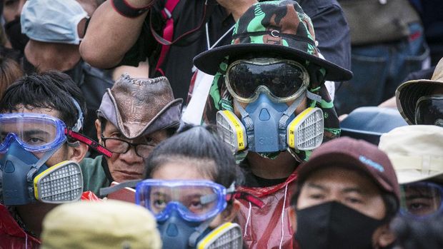 Pro-democracy protesters wear masks usually used to avoid tear gas during a protest in Bangkok, Thailand, Sunday, Sept. 20, 2020. The mass student-led rally that began Saturday is the largest in a series of protests this year, with thousands camping overnight near the royal palace, demanding for new elections and reform of the monarchy. (AP Photo/Wason Wanichakorn)