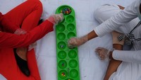 Dua bocah bermain congklak dengan menerapkan protokol kesehatan di Lapangan Merdeka, Medan, Sumatera Utara, Minggu (20/9/2020).