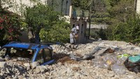 Mobil terkubur puing-puing bangunan yang hancur diterjang badai, Minggu (20/9).