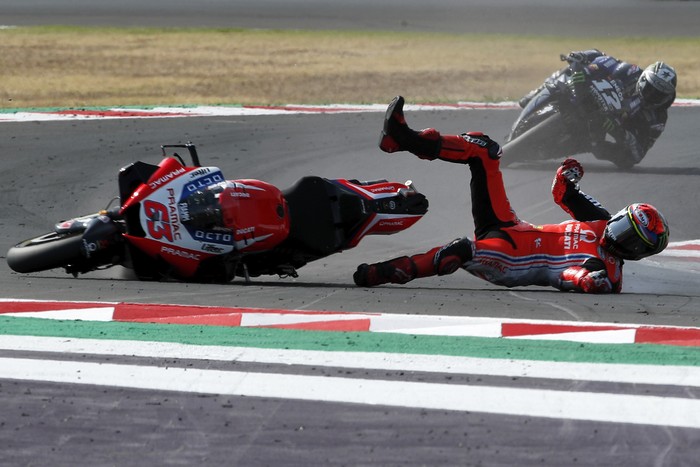 MotoGP rider Francesco Bagnaia of Italy falls down when leading the race ahead of Maverick Vinales of Spain, in the background, during the Emilia Romagna Motorcycle Grand Prix at the Misano circuit in Misano Adriatico, Italy, Sunday, Sept. 20, 2020. (AP Photo/Antonio Calanni)