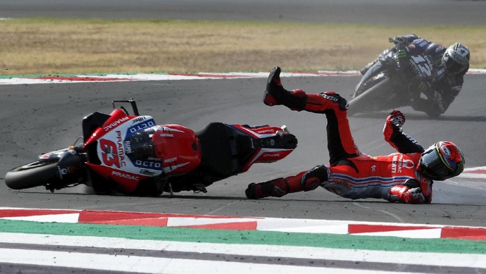 MotoGP rider Francesco Bagnaia of Italy falls down when leading the race ahead of Maverick Vinales of Spain, in the background, during the Emilia Romagna Motorcycle Grand Prix at the Misano circuit in Misano Adriatico, Italy, Sunday, Sept. 20, 2020. (AP Photo/Antonio Calanni)