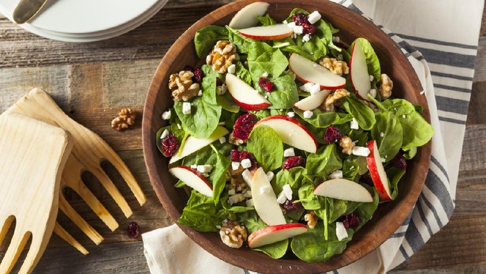 Ilustrasi salad buah dan sayur Homemade Autumn Apple Walnut Spinach Salad with Cheese and Cranberries