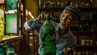 Di saat masa pandemi seperti ini, dia pun menyibukkan diri dengan merekatkan pecahan kaca untuk mebmuat botol lebih terlihat estetik. (AFP)