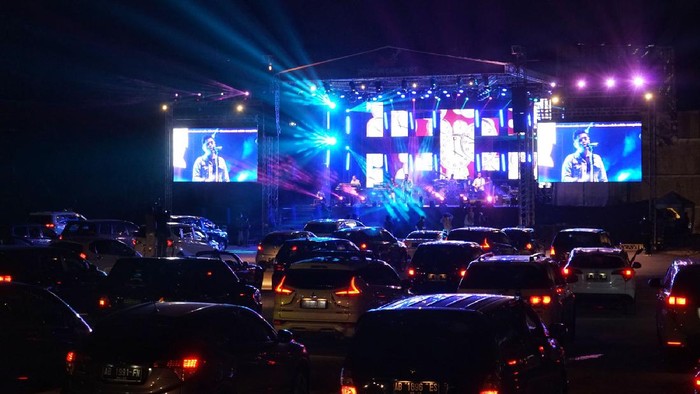 Penonton menyaksikan penampilan band Jikustik dari dalam mobil saat konser musik drive-in di Sleman City Hall, D.I Yogyakarta, Minggu (20/9/2020). Konser musik drive-in pertama di Yogyakarta itu digelar dengan menerapkan protokol kesehatan untuk mencegah penyebaran COVID-19. ANTARA FOTO/Andreas Fitri Atmoko/aww.