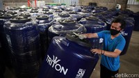 Pekerja membersihkan tangki air yang baru selesai diproduksi sebelum ditutup dengan plastik.