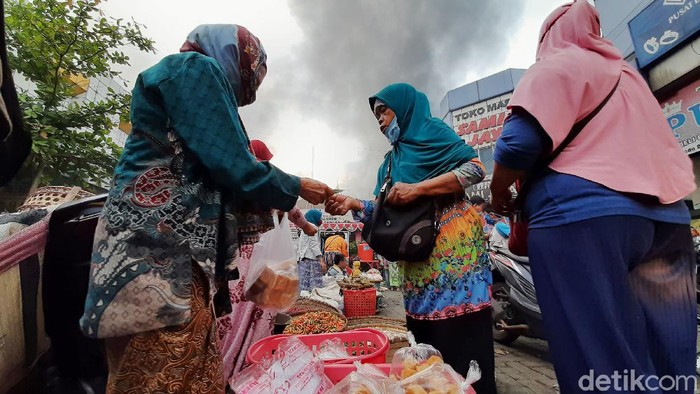 Momen Pedagang Berjualan Saat Pasar Wage Terbakar Kebakaran melanda Pasar Wage Purwokerto, Banyumas, Senin (21/9/2020) pagi. Sebagian pedagang yang berhasil menyelamatkan dagangan tetap berjualan saat api berkobar.