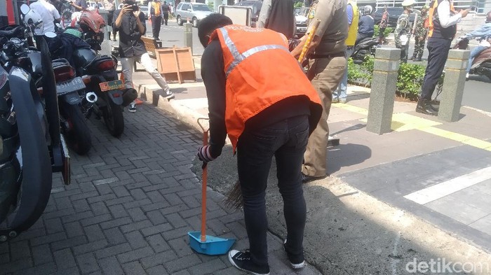 Pelanggar protokol kesehatan dihukum nyapu jalanan (Wilda Hayatun Nufus/detikcom).