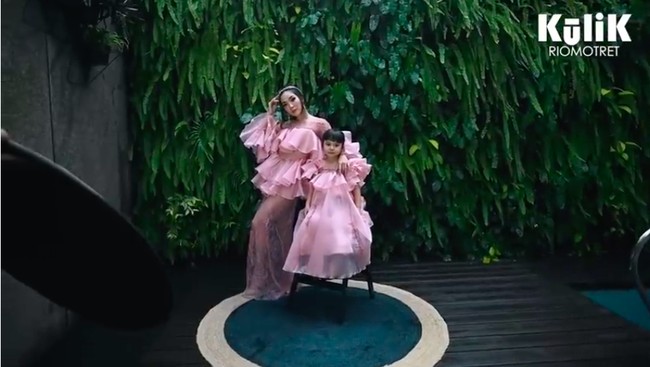 Tak cuma di dalam, pemotretan juga dilakukan di area kolam renang. Dengan latar vertical garden, Gisel dan putrinya memesona dalam balutan gaun berwarna pink. (Foto: YouTube/RIOMOTRET)