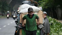 Pemulung menarik gerobak dengan dipenuhi barang bekas berjalan di Jalan Dr. Satrio, Kuningan, Jakarta, Senin (21/09/2020).