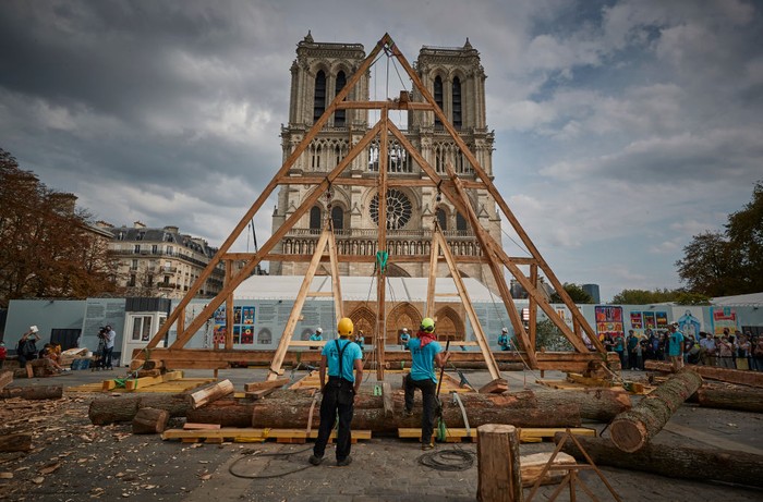 PARIS, FRANCE - SEPTEMBER 19: A member of the Charpentiers sans Frontièrs (Carpenters without Borders) works on the reconstruction of one of the missing timber frames of Notre-Dame Cathedral that was destroyed by the fire in front of the Cathedral on September 19, 2020 in Paris, France. Part of the 37th edition of the European Heritage Days, the iconic Parisian landmark aims at informing the public of the reconstruction plans related to the April 15, 2019 fire and aims to imporve the publics knowledge of Notre-Dames architecture and history. The extensive damage to the roof and spire of the 13th-century Notre Dame de Paris cathedral have proven reconstruction process to be much more complex than many anticipated. (Photo by Kiran Ridley/Getty Images)