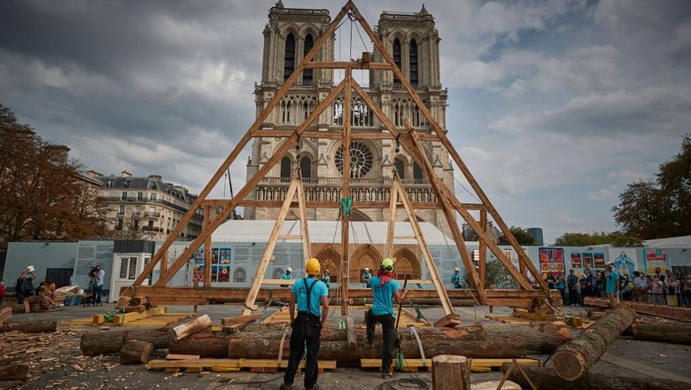 PARIS, FRANCE - SEPTEMBER 19: A member of the Charpentiers sans Frontièrs (Carpenters without Borders) works on the reconstruction of one of the missing timber frames of Notre-Dame Cathedral that was destroyed by the fire in front of the Cathedral on September 19, 2020 in Paris, France. Part of the 37th edition of the European Heritage Days, the iconic Parisian landmark aims at informing the public of the reconstruction plans related to the April 15, 2019 fire and aims to imporve the publics knowledge of Notre-Dames architecture and history. The extensive damage to the roof and spire of the 13th-century Notre Dame de Paris cathedral have proven reconstruction process to be much more complex than many anticipated. (Photo by Kiran Ridley/Getty Images)