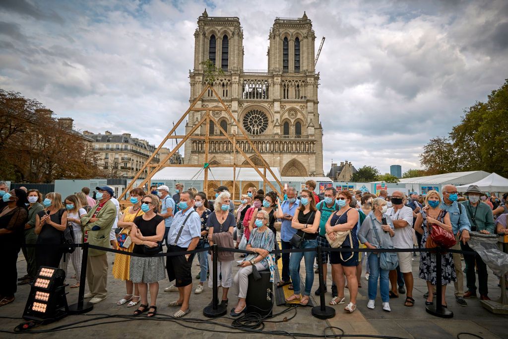 PARIS, FRANCE - SEPTEMBER 19: A member of the Charpentiers sans Frontièrs (Carpenters without Borders) works on the reconstruction of one of the missing timber frames of Notre-Dame Cathedral that was destroyed by the fire in front of the Cathedral on September 19, 2020 in Paris, France. Part of the 37th edition of the European Heritage Days, the iconic Parisian landmark aims at informing the public of the reconstruction plans related to the April 15, 2019 fire and aims to imporve the public's knowledge of Notre-Dame's architecture and history. The extensive damage to the roof and spire of the 13th-century Notre Dame de Paris cathedral have proven reconstruction process to be much more complex than many anticipated. (Photo by Kiran Ridley/Getty Images)