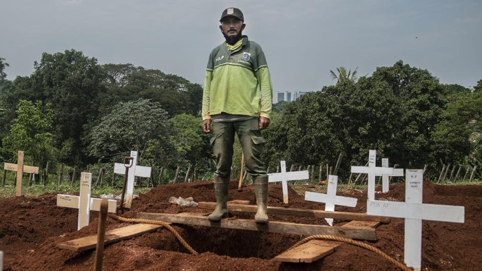 Petugas penggali makam jenazah COVID-19 menulis nama dan kelompok yang bertugas di komplek pemakaman Pondok Ranggon.