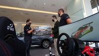 Presiden Direktur BMW Group Indonesia Ramesh Divyanathan (tengah) mencoba kendaraan kompetitif dari BMW Motorsport BMW Z4 GT3 secara virtual disaksikan Ketua Organizing Committee Balap di Rumah dan Anggota Komisi E-motorsports Ikatan Motor Indonesia (IMI) Rizal Sungkar (kiri) serta Anggota Organizing Committee Balap di Rumah, Rama Danindro (kanan) di Jakarta, Selasa (22/9). Foto: dok. BMW Indonesia