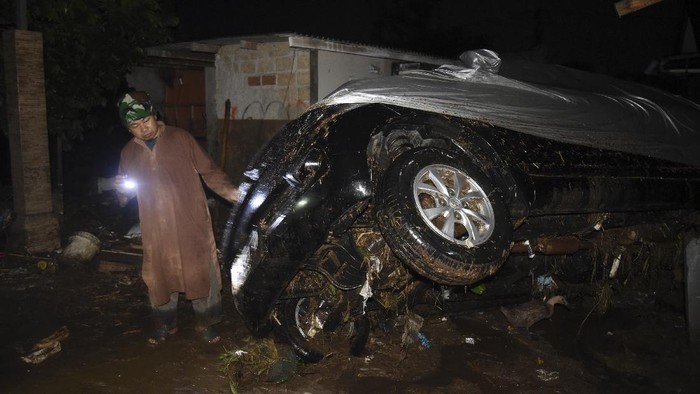BANJIR BANDANG SUKABUMI Warga melintasi genangan banjir bandang di Desa Mekarsari, Kecamatan Cicurug, Kabupaten Sukabumi, Jawa Barat, Senin (21/9/2020). Pada pukul 20.30, Pusat Pengendali Operasi (Pusdalops) BNPB mencatat sebanyak 12 rumah hanyut, 85 rumah terendam dan 1 unit mobil tersapu saat banjir bandang. ANTARA FOTO/Iman Firmansyah/agr/pras.