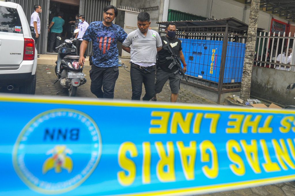 Kepala BNN Provinsi Sumatera Selatan Brigjen Pol Jhon Turman Panjaitan (kanan) didampingi Anggota BNN mengawal tersangka yang merupakan Anggota DPRD Kota Palembang 2019-2024 dari Partai Golkar Doni (kiri) usai melakukan penggerebekan di Palembang, Sumatera Selatan, Selasa (22/9/2020). BNN Mengamankan Anggota DPRD Kota Palembang 2019-2024 dari Partai Golkar Doni sebagai bandar narkoba dan 5 orang tersangka lainnya serta barang bukti narkoba jenis sabu seberat 5kg dan 30.000 butir ekstasi. ANTARA FOTO/R.M. Amri Ramdhani/Lmo/hp.