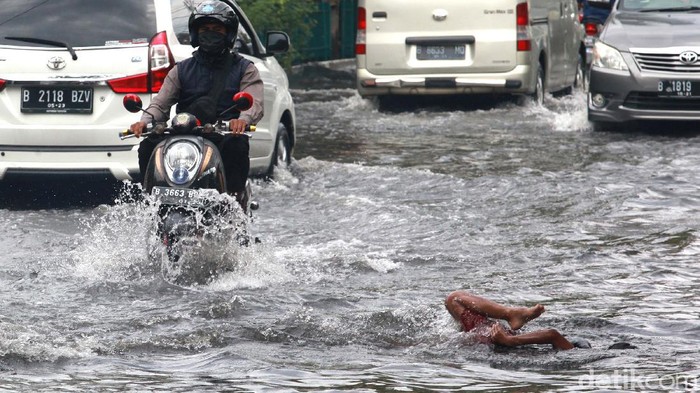 Pasca hujan deras semalem, terdapat genangan air di depan Perumahan Green Garden, Kedoya, Jakarta. Genangan ini menjadi tempat main anak-anak.