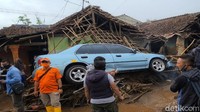 Sebuah mobil terseret dan nyangkut di puing-puing.