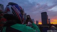Seorang ojol bahkan berhenti sejenak untuk mengabadikan lansekap senja.