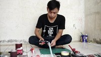 Herman memulai membuat miniatur motor dengan memotong dan membelah pipa, kemudian meratakannya dengan sedikit dipanaskan.